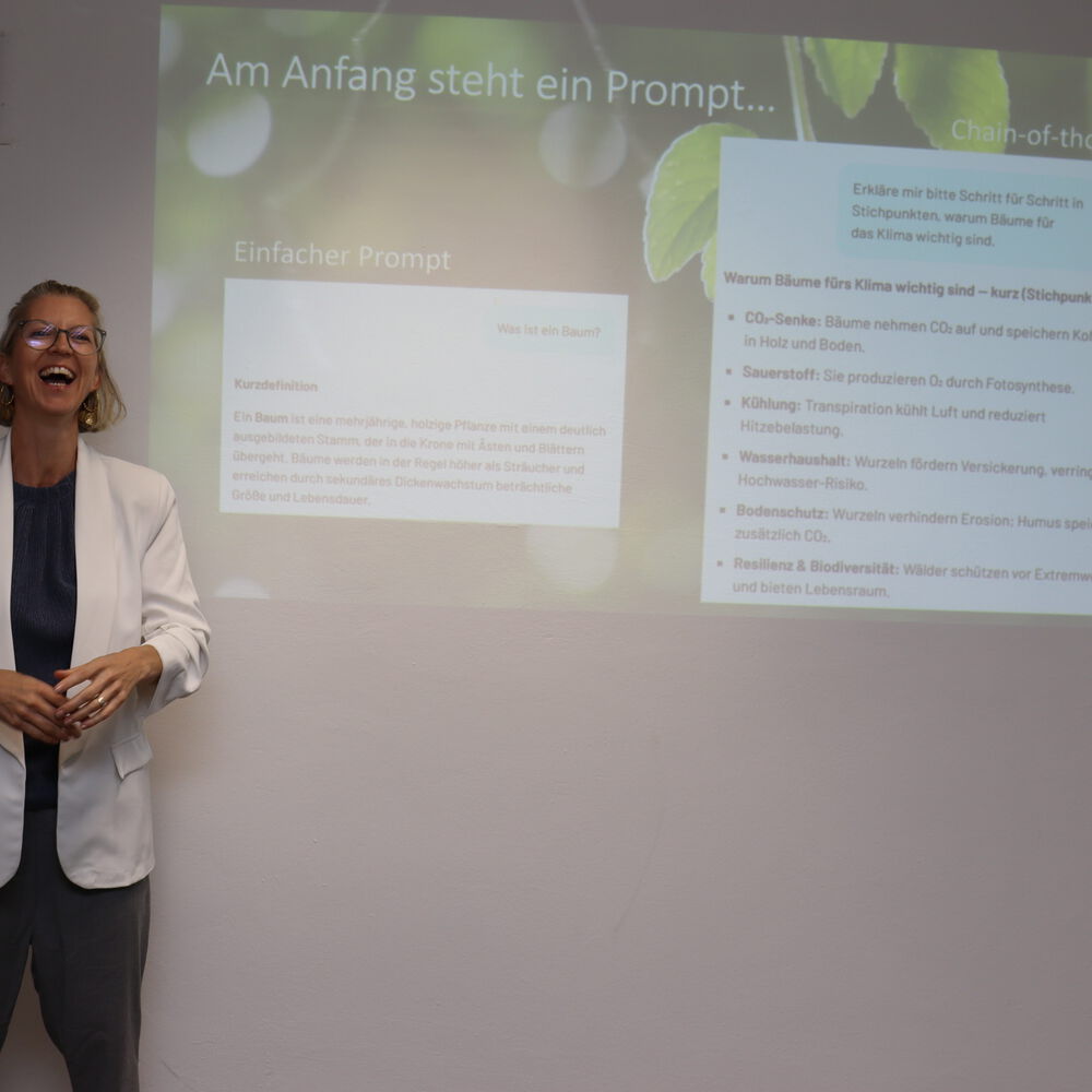 Lehrerin lachend vor der Projektion mit anleitung für gute KI Prompts
