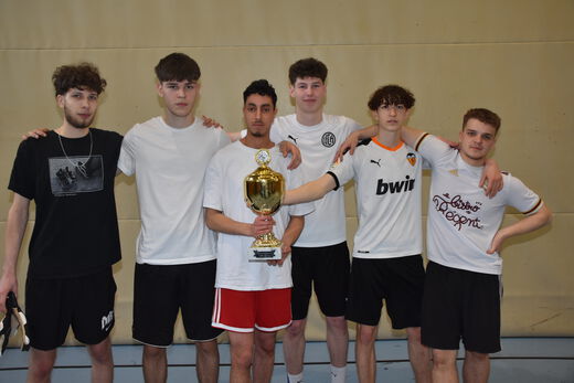 Bild, dass die 6 Spieler eines Teams mit dem Pokal zeigt.